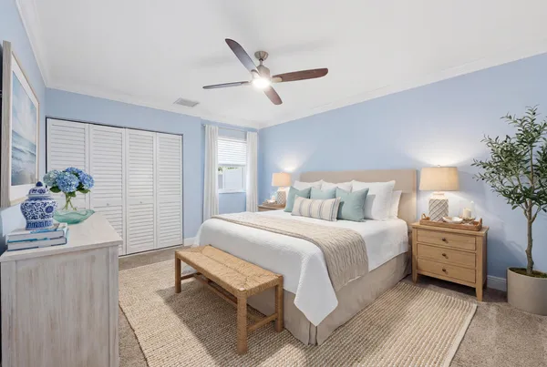 a spacious bedroom with a bed and a potted plant
