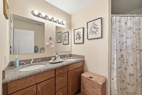 a bathroom with a granite countertop sink a mirror a vanity and a shower
