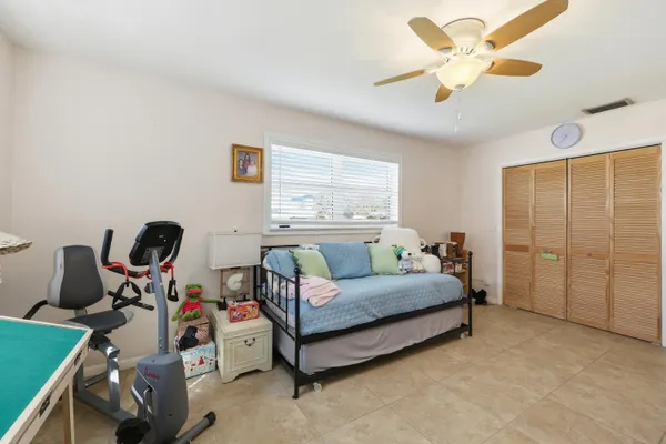 a bedroom with a bed gym equipment and a window
