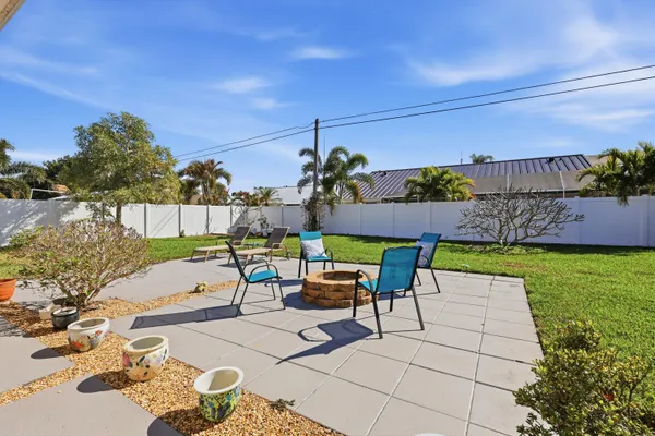 a view of a patio with couches table and chairs and potted plants