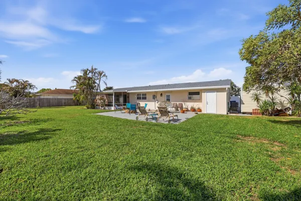 a view of house with yard and outdoor seating