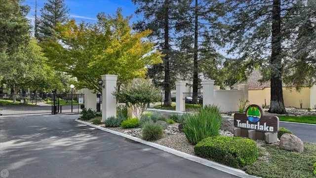 a backyard of a house with table and chairs plants and large trees
