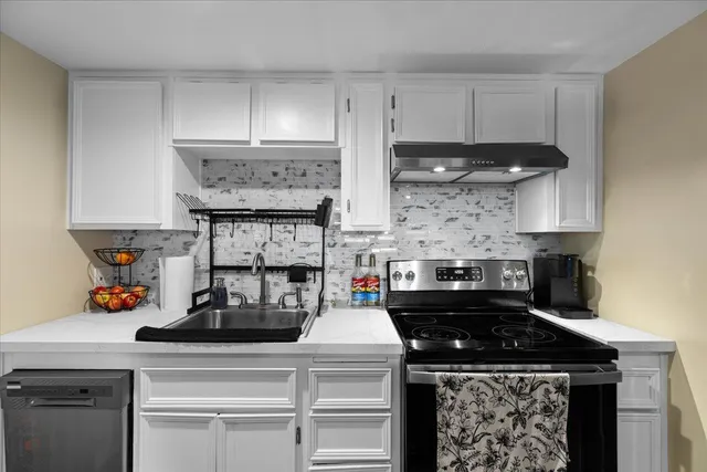 a kitchen with stainless steel appliances a refrigerator a sink and cabinets