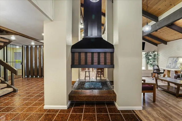 a dining hall with stainless steel appliances kitchen island granite countertop a table and chairs in it