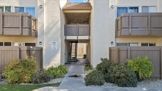 a view of a house with a small yard and wooden floor and fence