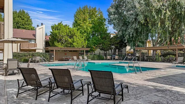 a view of a swimming pool with a patio and a yard