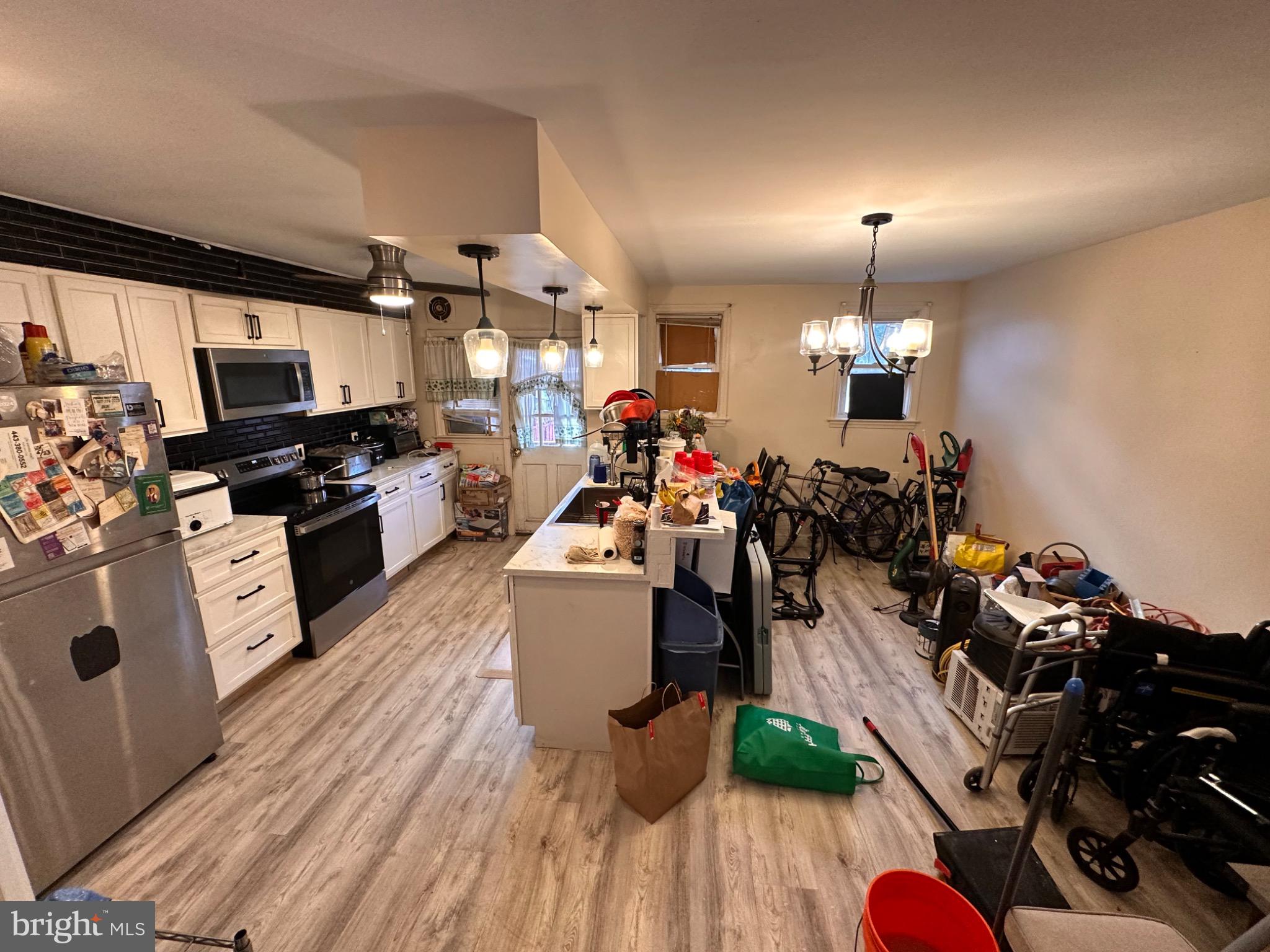 918 Cooks Lane Baltimore, MD 21229 - Photo 4 of 18 a view of a kitchen with kitchen island wooden floor and stainless steel appliances