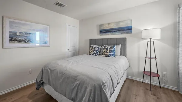 a bedroom with a bed and a painting on the wall