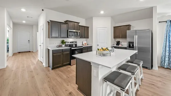 a kitchen with stainless steel appliances granite countertop a table chairs stove and kitchen island