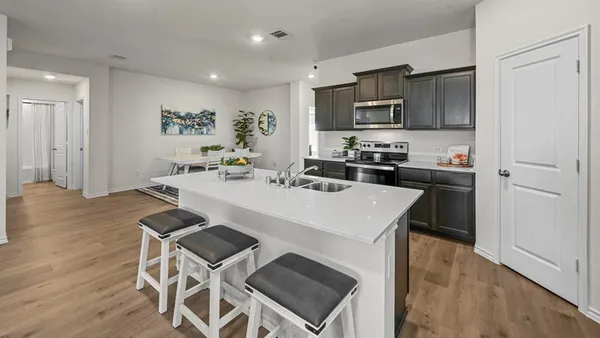 a kitchen with a sink appliances and cabinets