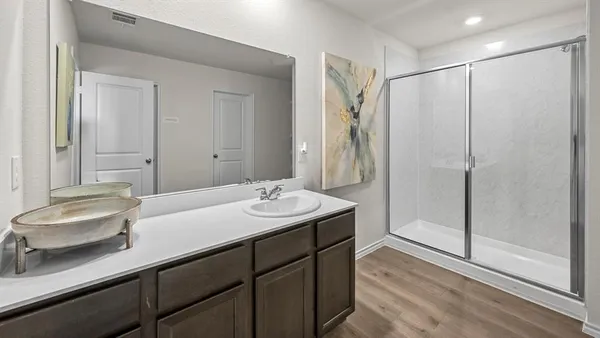 a bathroom with a double vanity sink mirror and shower