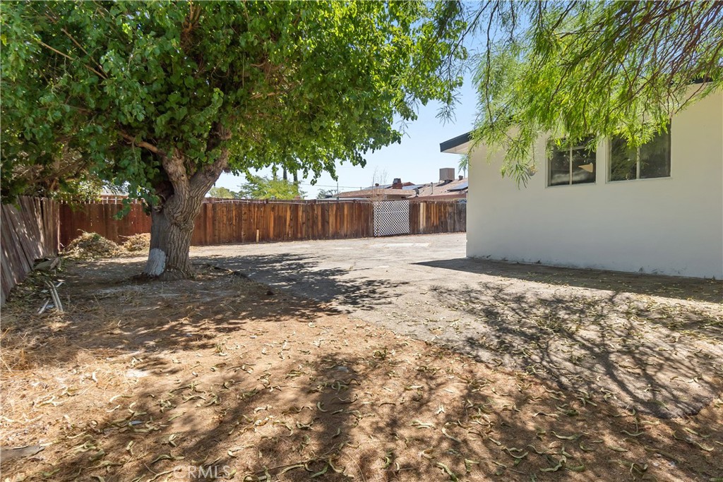 38995 Juniper Tree Road Palmdale, CA 93551 - Photo 7 of 22 a backyard of a house with large trees and wooden fence