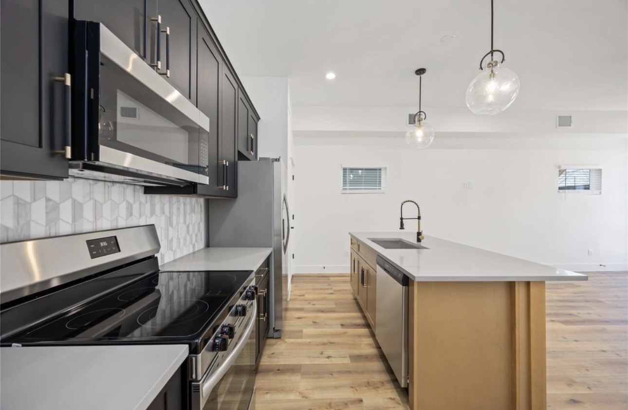 8011 Cora Street, Unit A Houston, TX 77088 - Photo 5 of 14 a kitchen with stainless steel appliances a sink and a stove