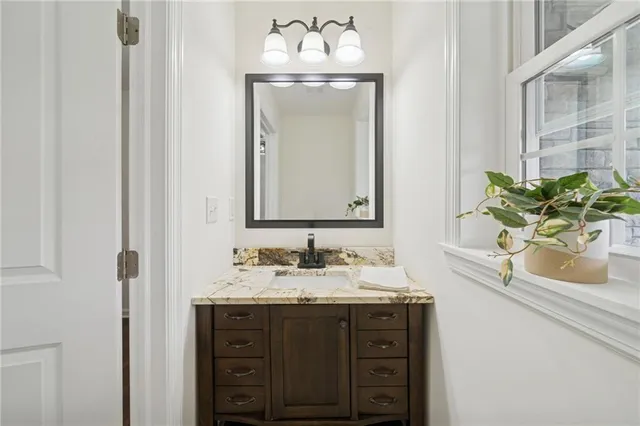 a bathroom with a sink vanity granite and a mirror