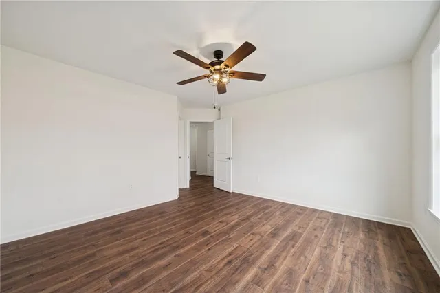 a view of a big room with wooden floor and a ceiling fan