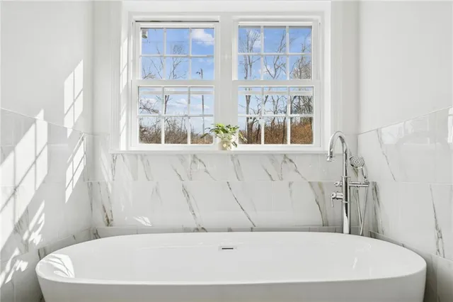 a white bath tub sitting next to a window