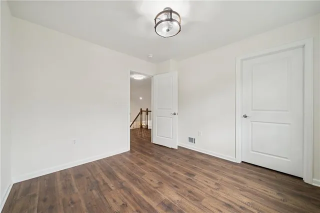 a view of empty room with wooden floor and window