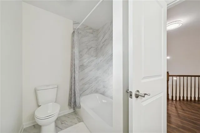 a bathroom with a toilet and a shower