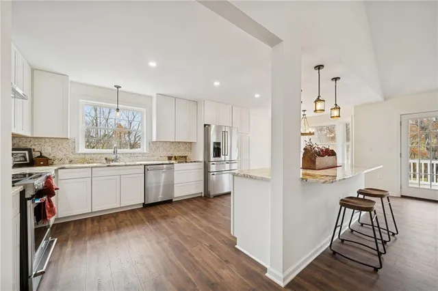 a kitchen with a refrigerator and a stove top oven
