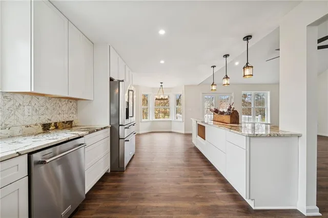 a large kitchen with stainless steel appliances granite countertop a lot of counter space and wooden floor