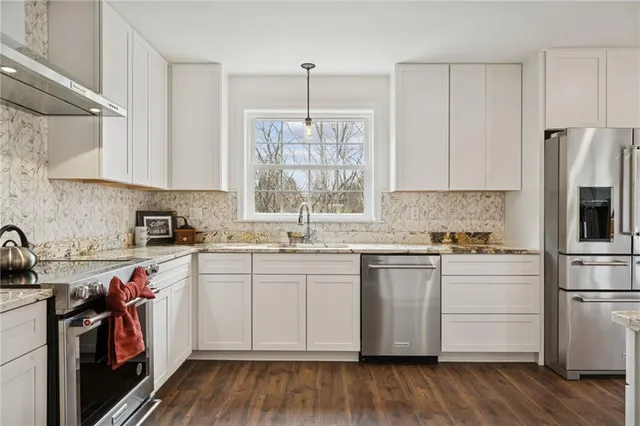 a kitchen with a white cabinets and wooden floor