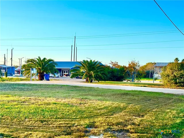 a view of a big yard with table and chairs under an umbrella