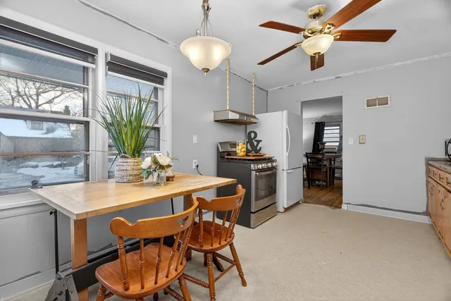 a view of a dining room with furniture and a chandelier fan