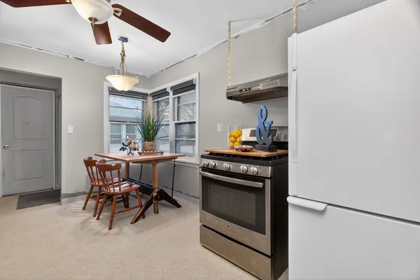 a kitchen with a table chairs and a refrigerator