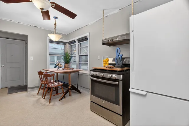 a kitchen with a table chairs and a refrigerator