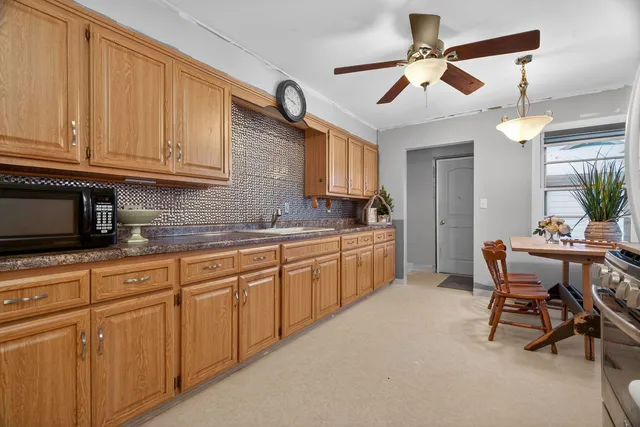a kitchen with granite countertop a sink a stove and cabinets