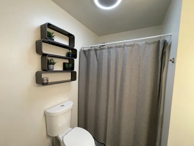 a bathroom with a toilet and a mirror