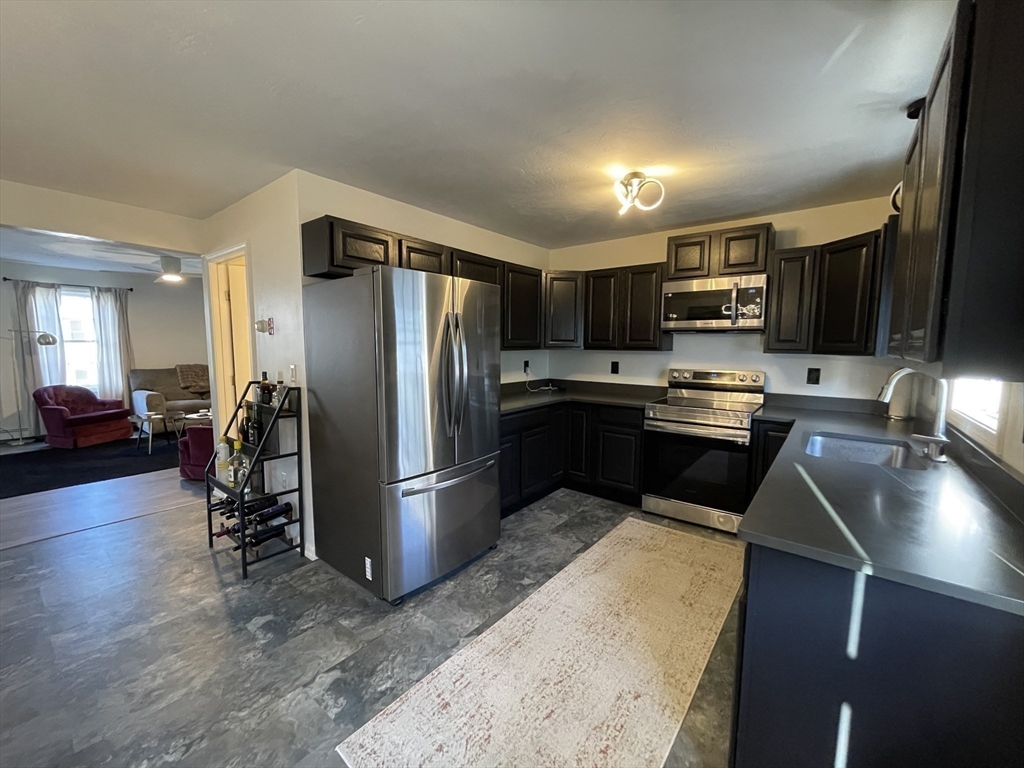 33 Sigel Street, Unit B Worcester, MA 01610 - Photo 8 of 28 a kitchen with stainless steel appliances granite countertop a refrigerator stove and sink