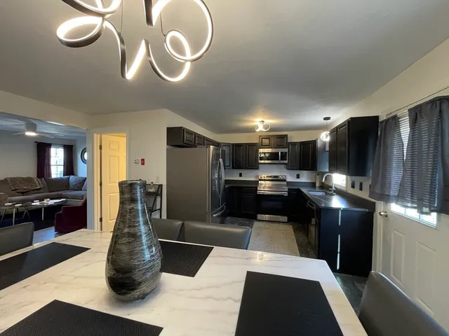 a kitchen with stainless steel appliances kitchen island granite countertop a stove and cabinets