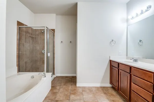 a bathroom with a tub sink and mirror