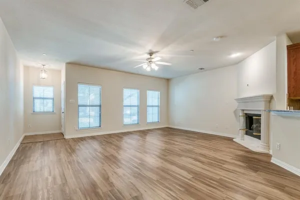 a view of an empty room with a fireplace and a window