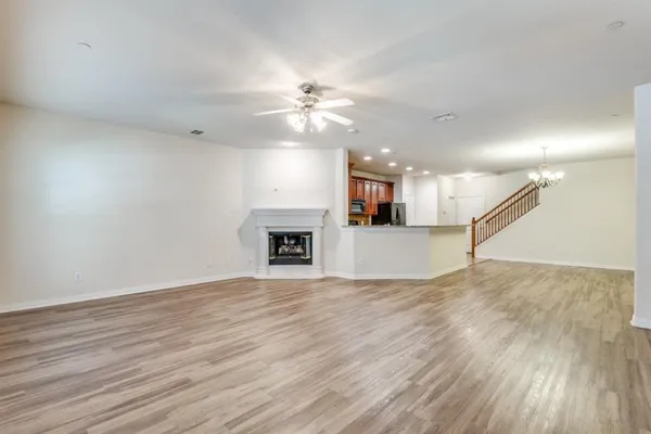 a view of empty room with wooden floor and ceiling fan