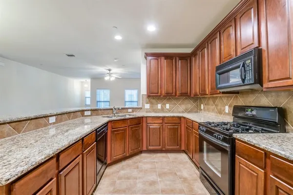 a kitchen with stainless steel appliances granite countertop a sink stove and cabinets