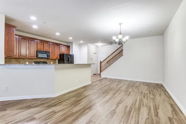 a view of open kitchen with wooden floor and staircase
