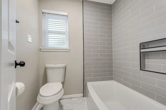 a bathroom with a toilet a sink and bathtub