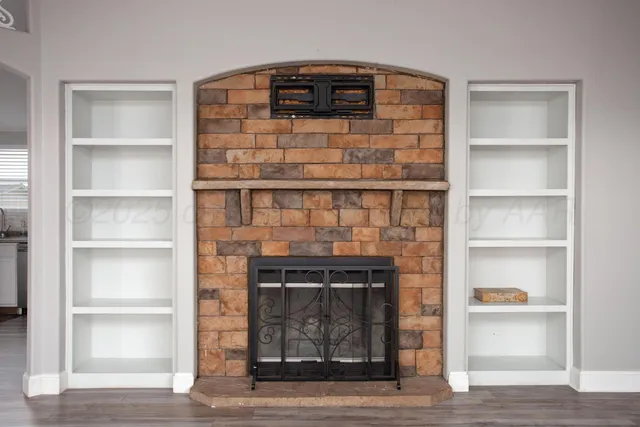 a living room with a wooden floor and a fireplace