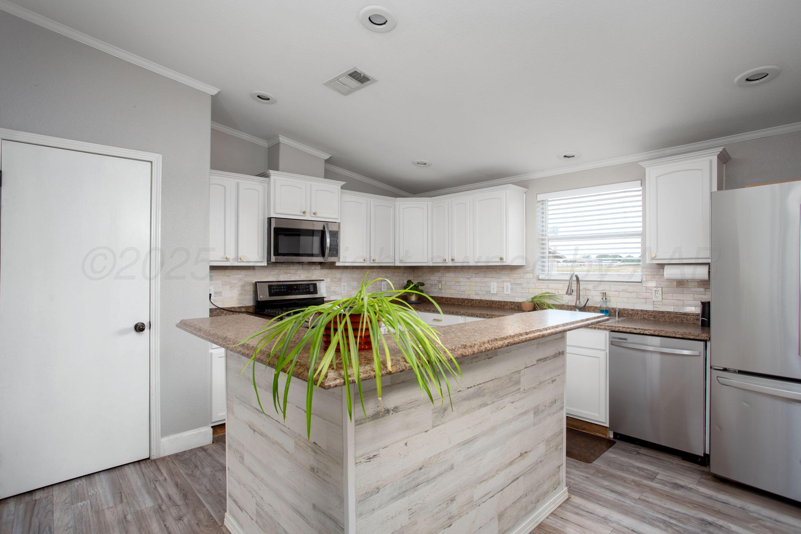11000 Fox Street Amarillo, TX 79118 - Photo 12 of 40 a kitchen with stainless steel appliances granite countertop a refrigerator a stove top oven a sink and dishwasher with wooden floor