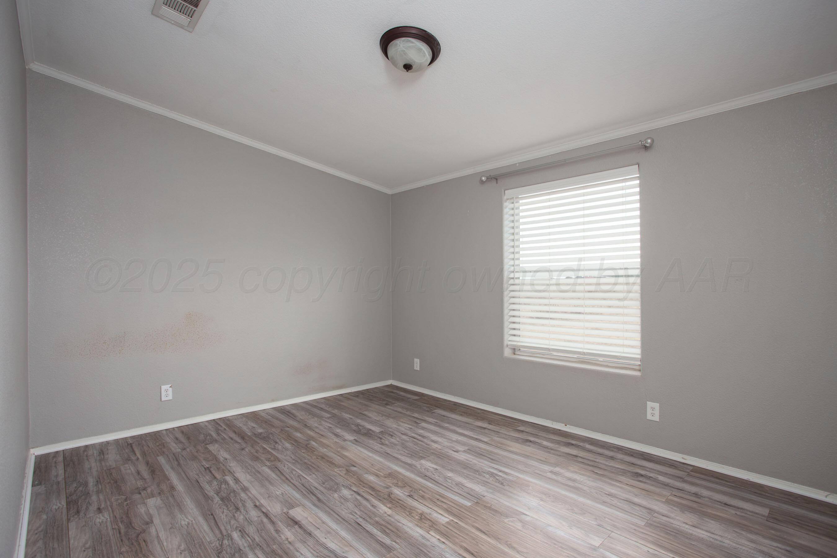11000 Fox Street Amarillo, TX 79118 - Photo 22 of 40 wooden floor in an empty room with a window