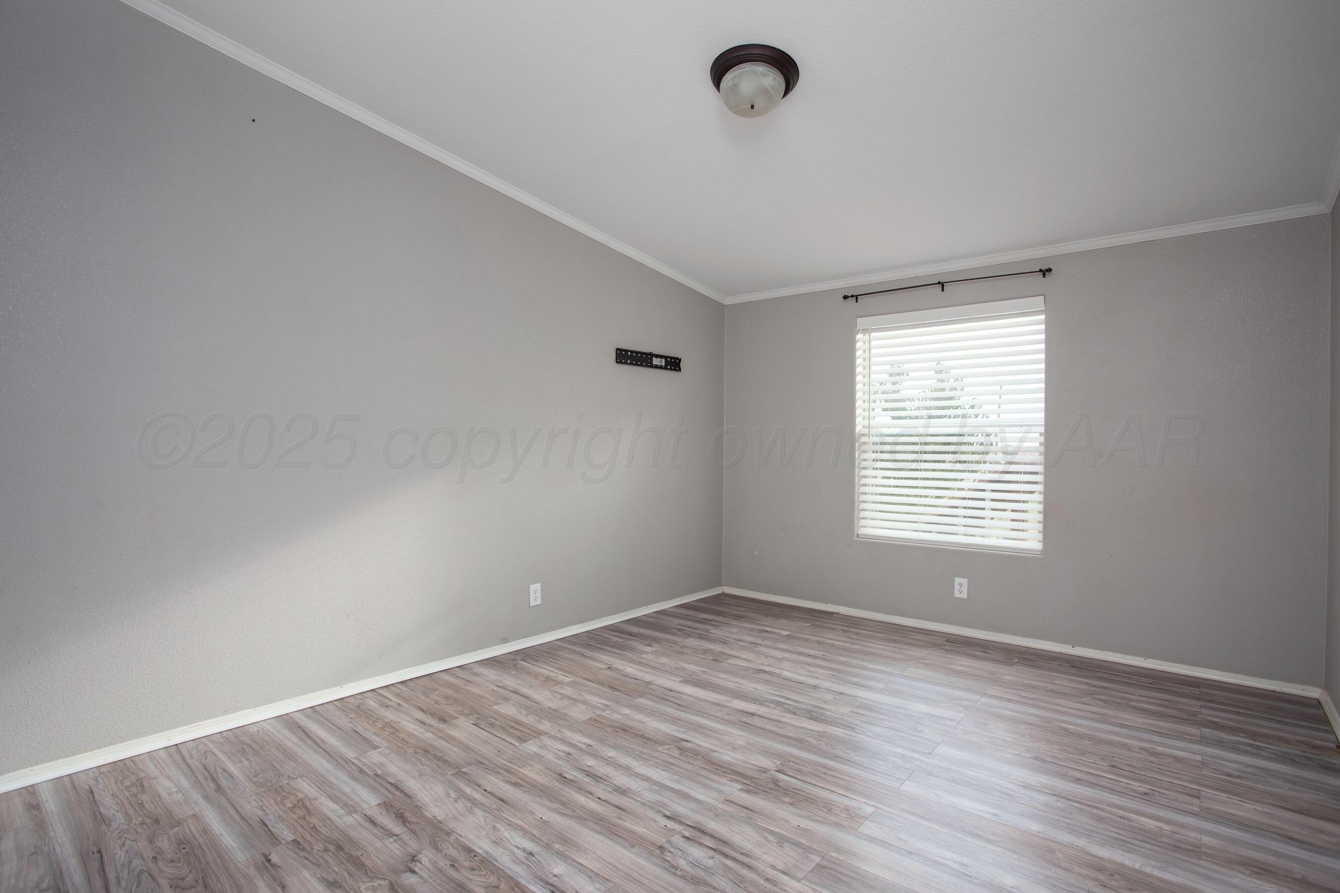 11000 Fox Street Amarillo, TX 79118 - Photo 33 of 40 a view of an empty room with wooden floor and a window