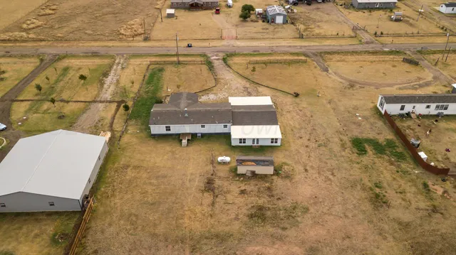 an empty room with wooden floor fireplace and windows