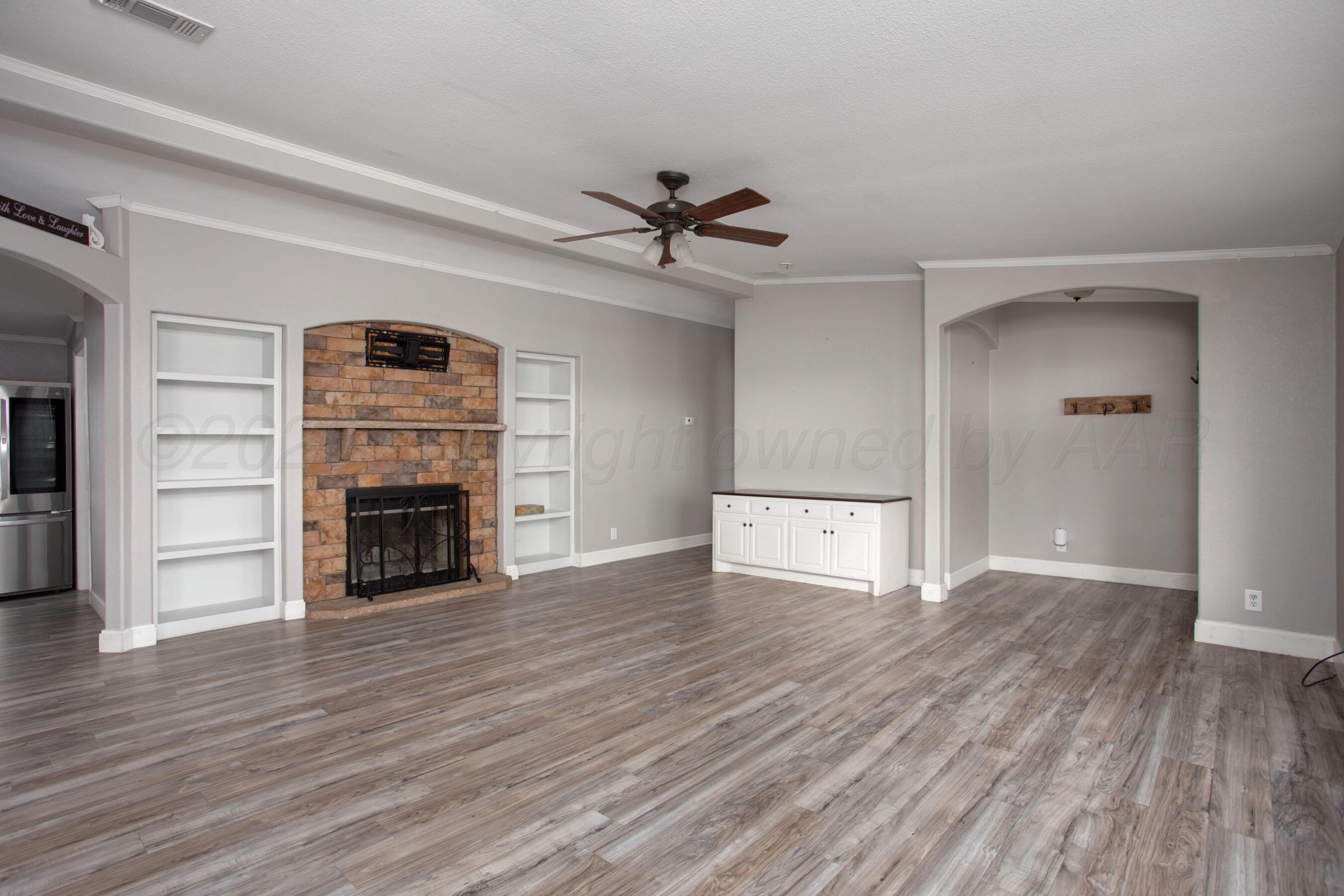 11000 Fox Street Amarillo, TX 79118 - Photo 39 of 40 an empty room with wooden floor fireplace and windows