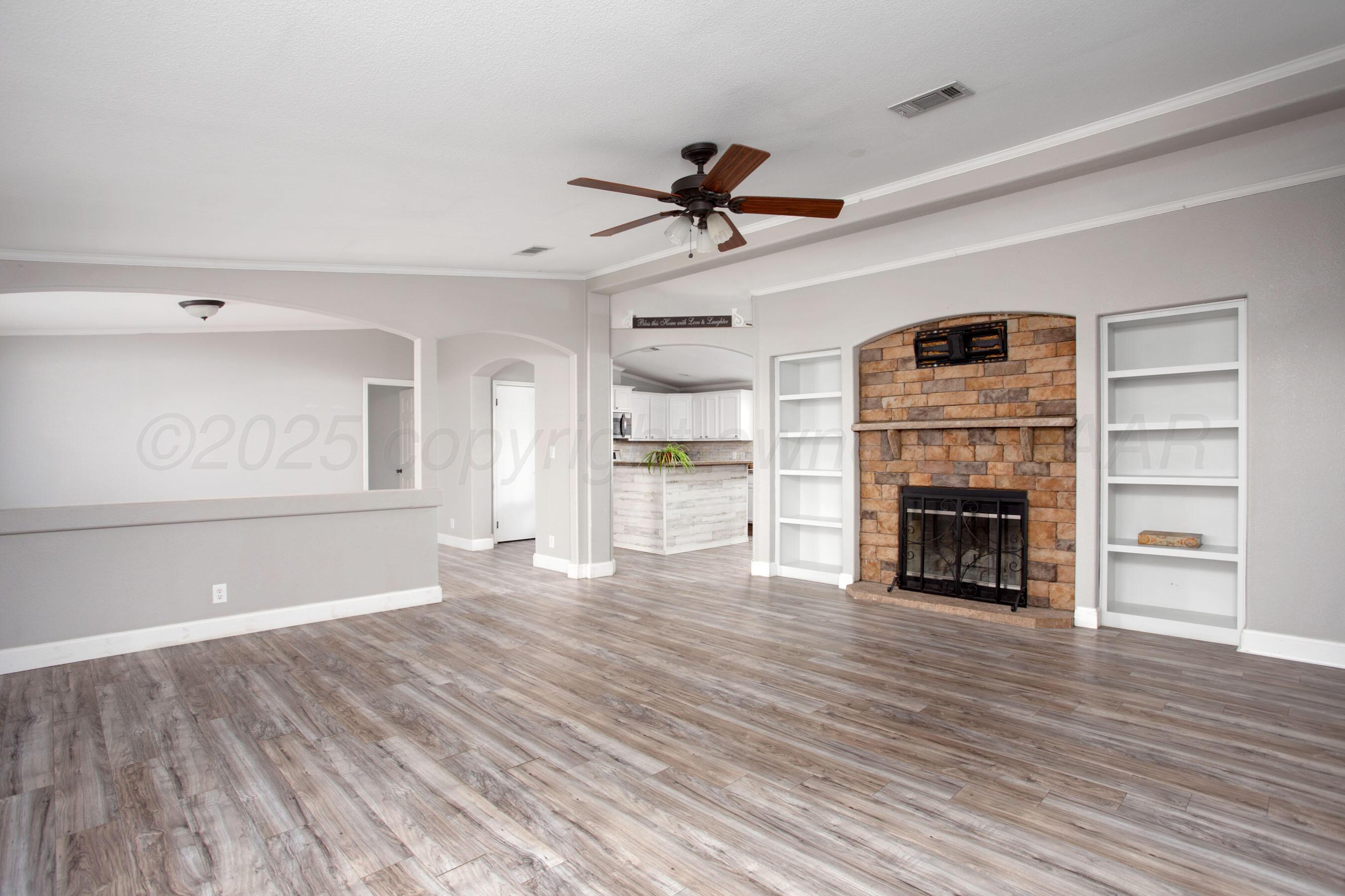 11000 Fox Street Amarillo, TX 79118 - Photo 7 of 40 a view of a livingroom with wooden floor a fireplace and window