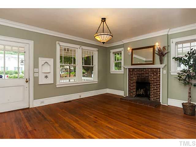 1519 Hanover Street Raleigh, NC 27608 - Photo 3 of 18 a view of an empty room with wooden floor fireplace and a window