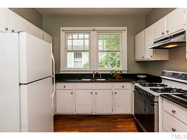 1519 Hanover Street Raleigh, NC 27608 - Photo 8 of 18 a kitchen with granite countertop a refrigerator a sink a stove and white cabinets