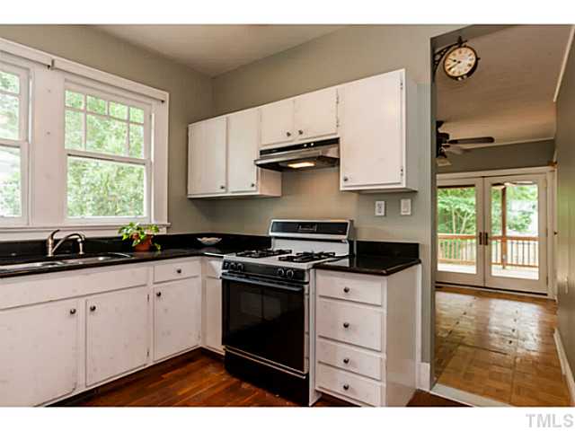 1519 Hanover Street Raleigh, NC 27608 - Photo 9 of 18 a kitchen with stainless steel appliances granite countertop a sink stove and white cabinets