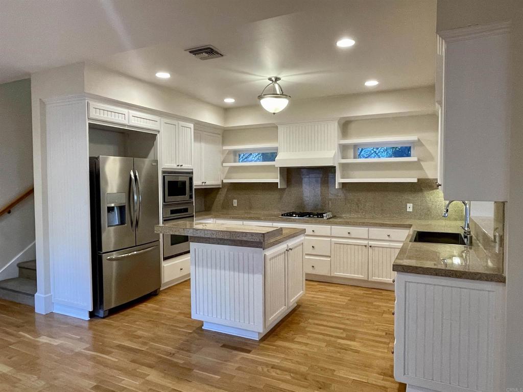 428 La Veta Avenue Encinitas, CA 92024 - Photo 4 of 25 a kitchen with stainless steel appliances granite countertop a refrigerator a stove and a sink